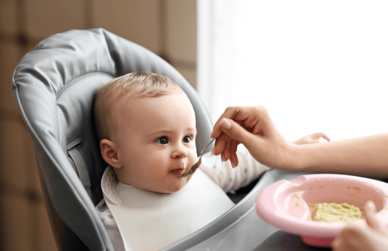 Parent donnant la purée à la cuillère à son bébé lors du repas